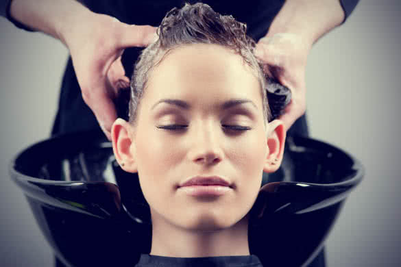 Beautiful young woman getting a hair wash massage