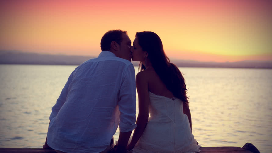 romantic couple kissing on sunset
