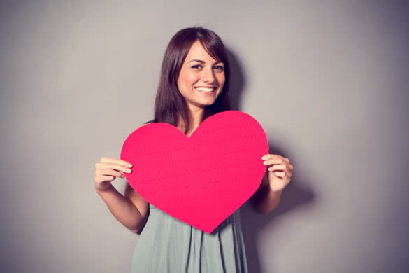 smiling girl holding heart sign