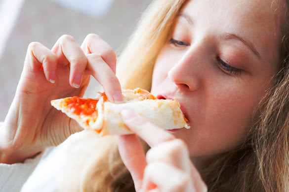Young happy woman eating of pizza