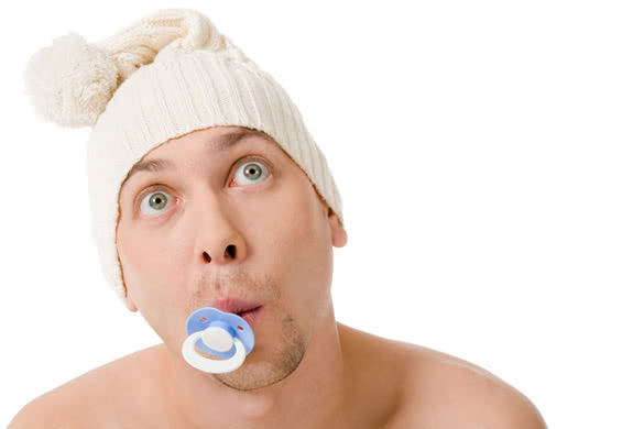 Baby man with pacifier in mouth looking surprisingly