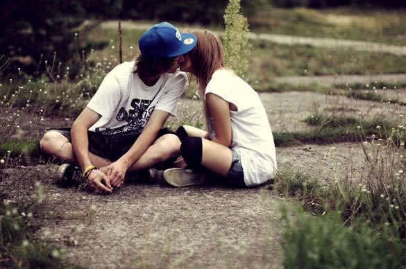 couple sitting on the ground and kissing