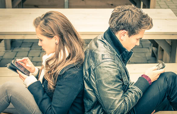couple-texting-sitting-on-the-bench