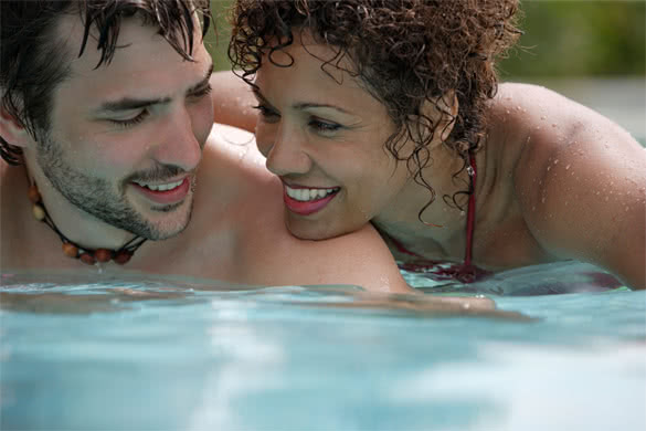 older-woman-younger-man-couple-smiling-in-the-pool