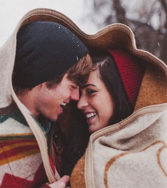 couple-with-a-blanket-in-the-winter-smiling