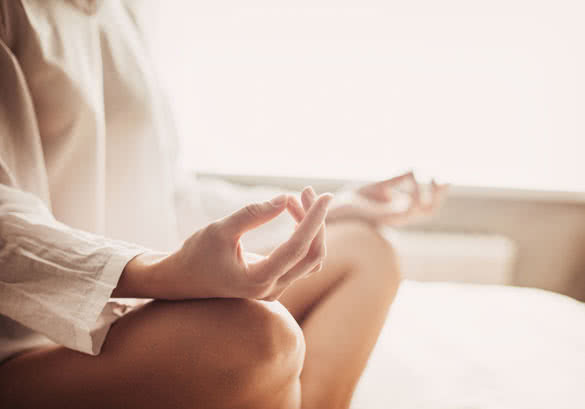 Woman meditating in the lotus position closeup