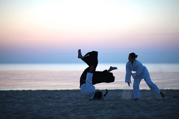 Aikido practice on the beach at sunset