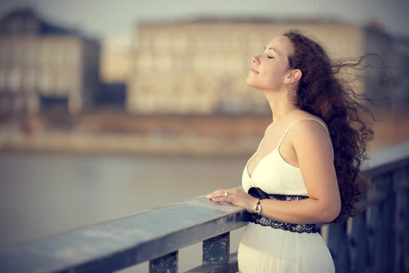 beautiful woman breathing air on bridge