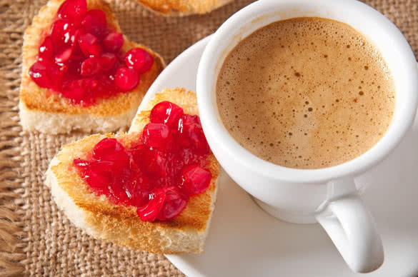 heart-shaped toast with jam and a cup of coffee