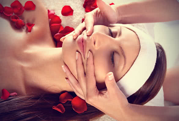 Girl with roses receiving facial massage
