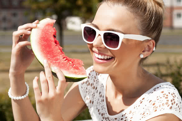 Young smiling woman takes watermelon