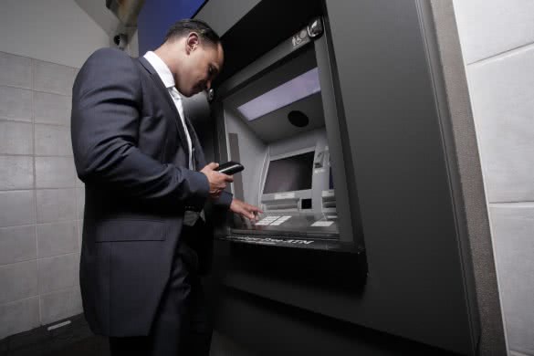 businessman taking cash from atm machine