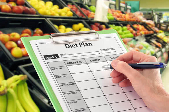 Hand Writing a Diet Plan by Supermarket Fruit
