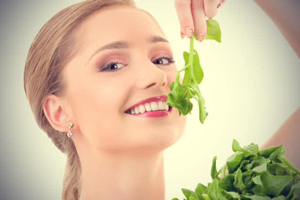 Happy woman eating Spinach