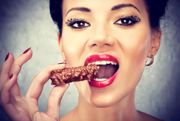 Pretty Woman with Makeup Eating Chocolate