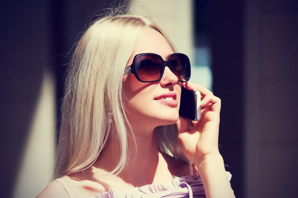 blonde girl with sunglasses talking on a cell phone