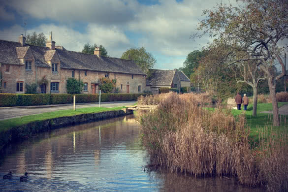 row of cotswold cottages on a river