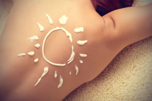 sun protection cream on womans back