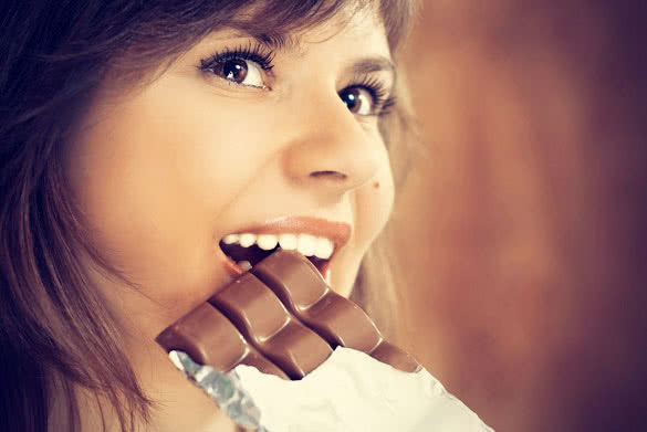 woman biting a bar of chocolate