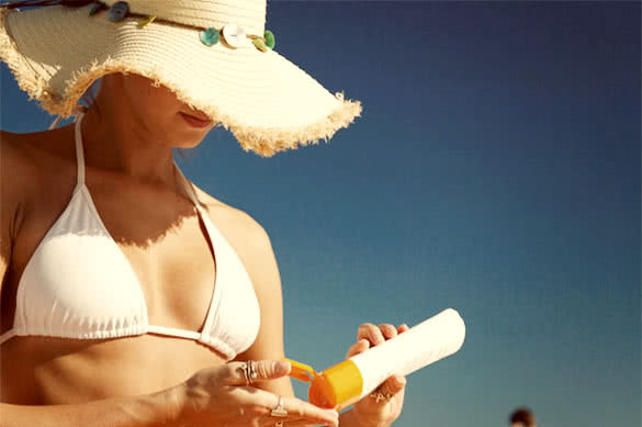 woman with sun protection cream on beach
