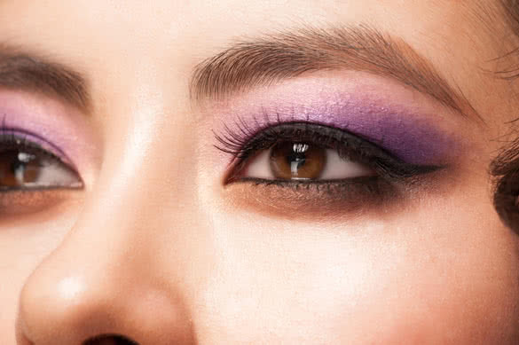 young asian woman eye with bright violet makeup