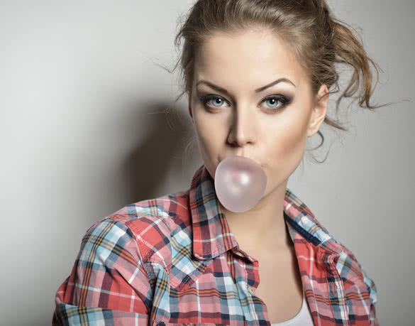 Beautiful teen girl inflating bubble of chewing gum