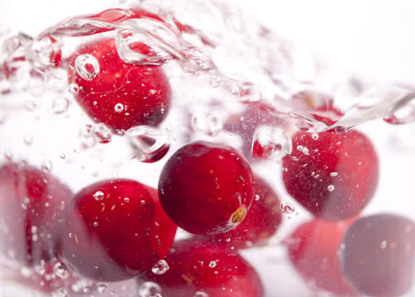 Cranberries splashing into water