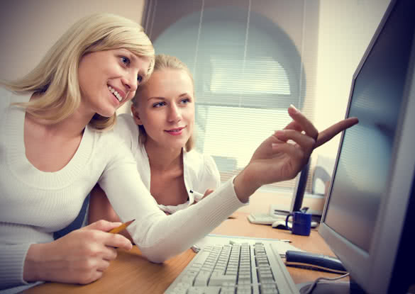 Woman Helping Other Woman on Project