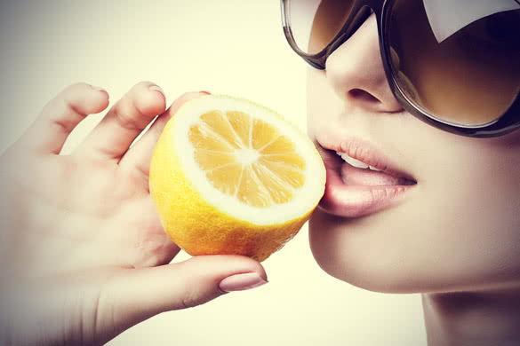Woman With Sunglasses Eating Lemon