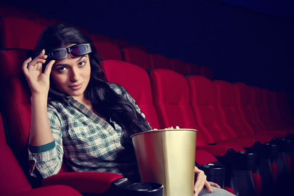 girl with 3d glasses and popcorns in cinema