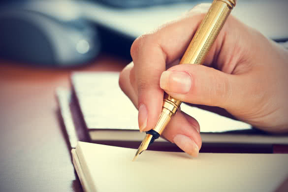 gold pen in womans hand
