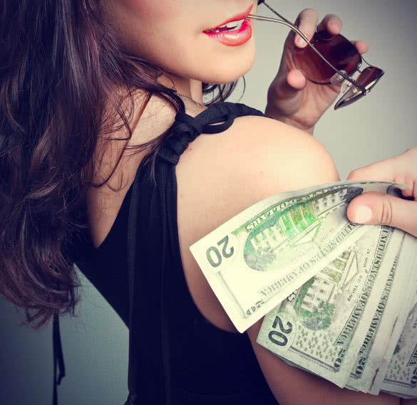 man holding money bills over her right shoulder