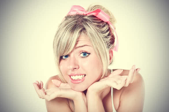 Young beautiful blond woman with pink bow apologizing