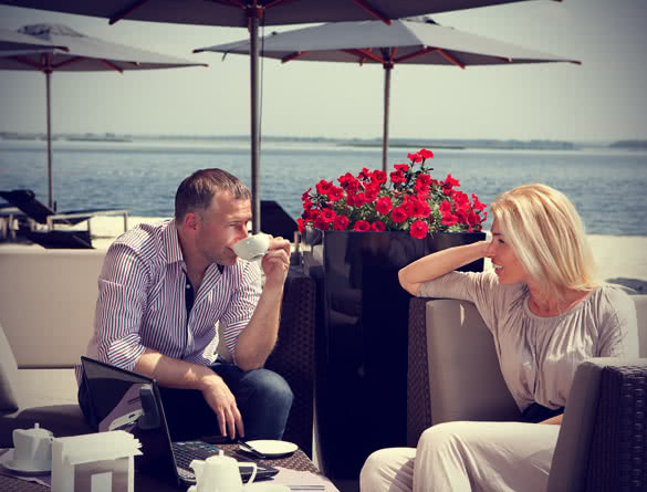 man and women drinking coffee at the seaside