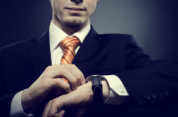 man in suit looking at his watch