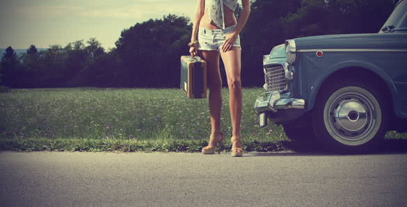 young girl with suitcase and vintage car