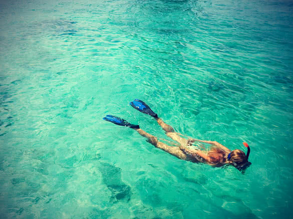 young woman is snorkeling in tropical lagoon