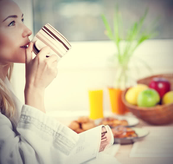 Beautiful calm young woman having morning coffee