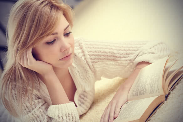 blonde young woman reading book