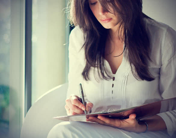 woman writes on a paper