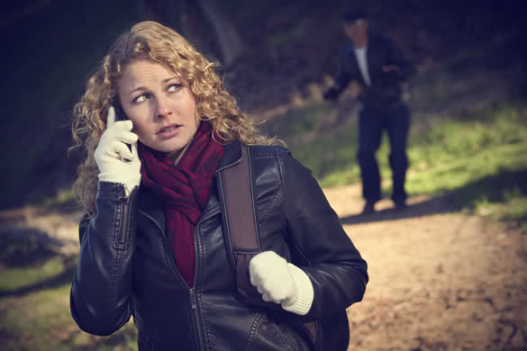 Woman Calling on Cell Phone with Mysterious Strange Man Lurking Behind Her