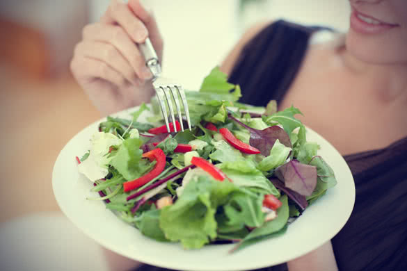 close up of a woman eating a salad