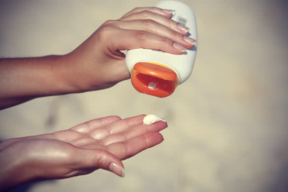 close up of women hands receiving sunblock cream lotion