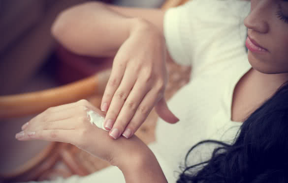 female applying cream to her hands