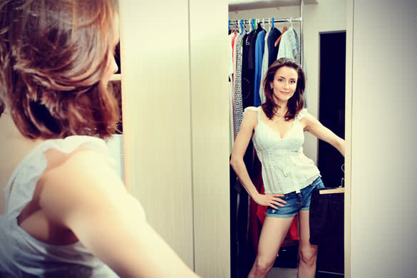 Beautiful woman looking at her clothes in a wardrobe at home
