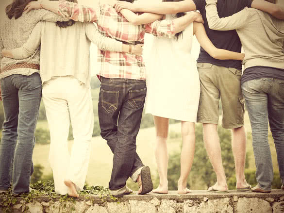 Rear view of group of friends hugging