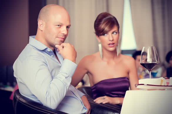 man thinking with suspicious woman at restaurant table