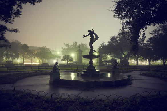 silhouette of a statue and fountain at night in audubon park