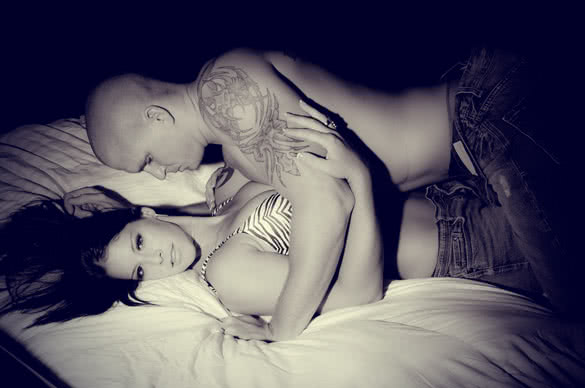 tattooed man and woman in bed