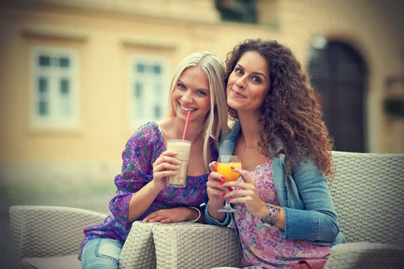 two woman friends at cafe having fun and talking